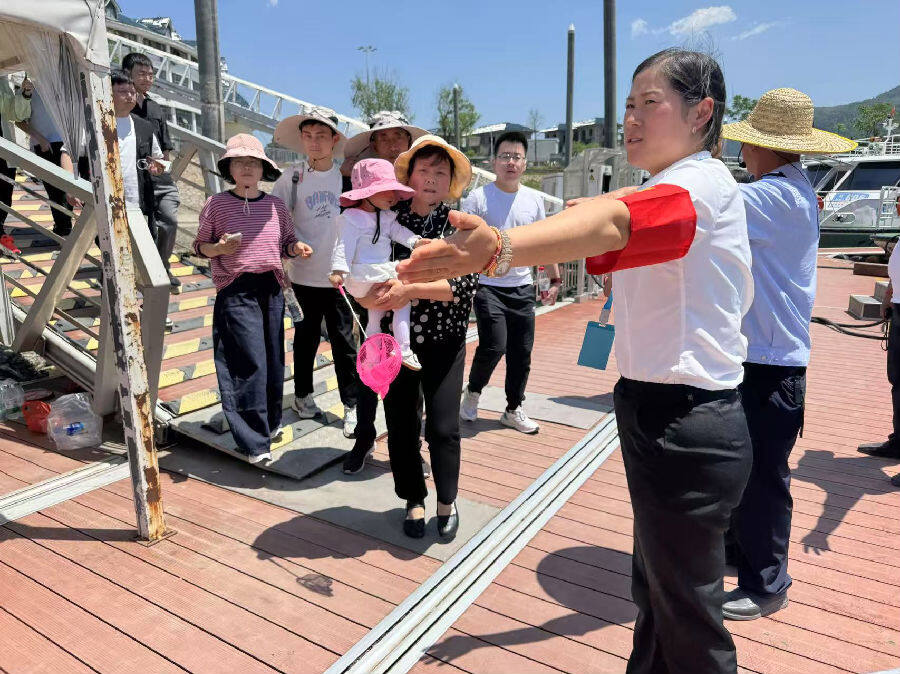 女党员船长正在仙岛湖引导游客安全上船（陈际际 摄）
